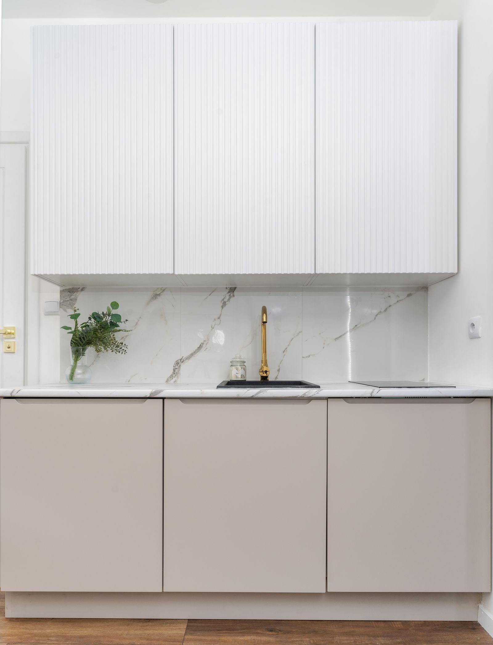 Luxury kitchen with marble backsplash and gold fixtures in an Ivory Court villa