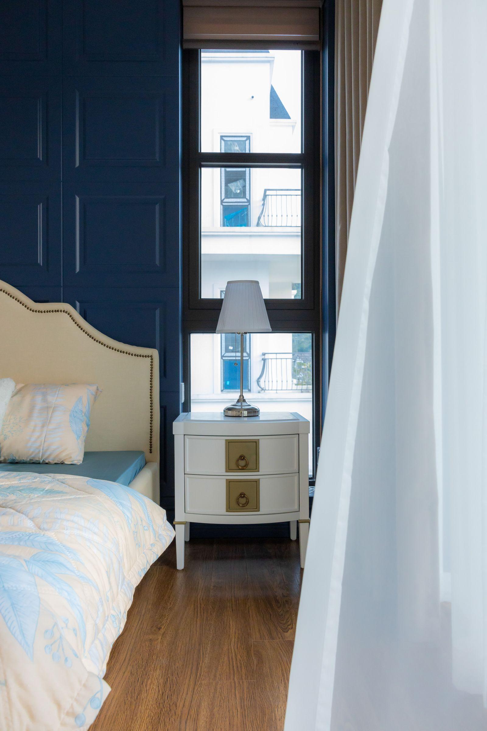 Primary bedroom with beige headboard and wood flooring in an Ivory Court villa